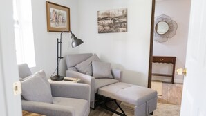 A modern living room with a grey sectional sofa, a small wooden table, a floor lamp, and a mirror on the wall. - Quiet farm stay, hike, mushroom hunt, see the animals, relax, so much more! (Edmonton)