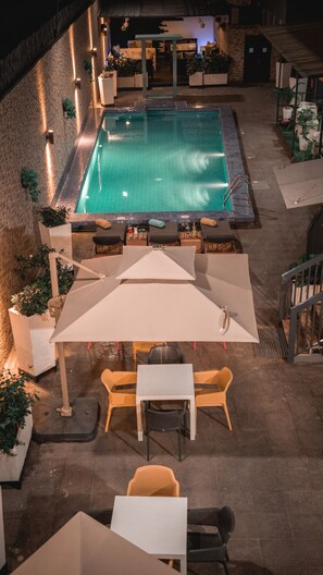 An outdoor swimming pool area with a seating arrangement and potted plants. - Platinum Cocotiers Hotel (Douala)