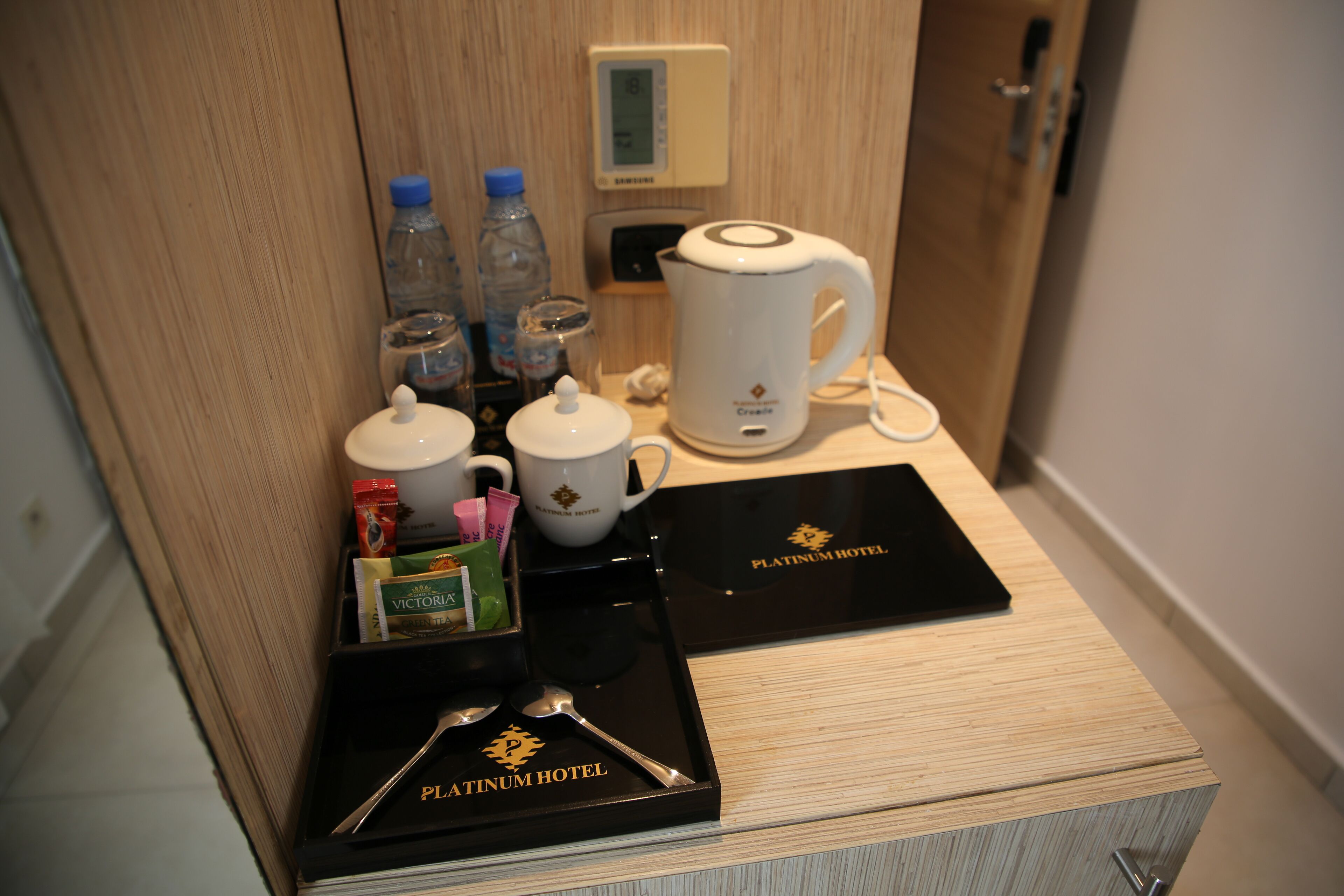 A hotel room's minibar with a coffee maker, tea kettle, and various toiletries.