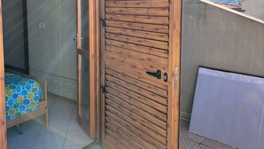 Porta in legno aperta che dà su una stanza con un letto e un armadio.