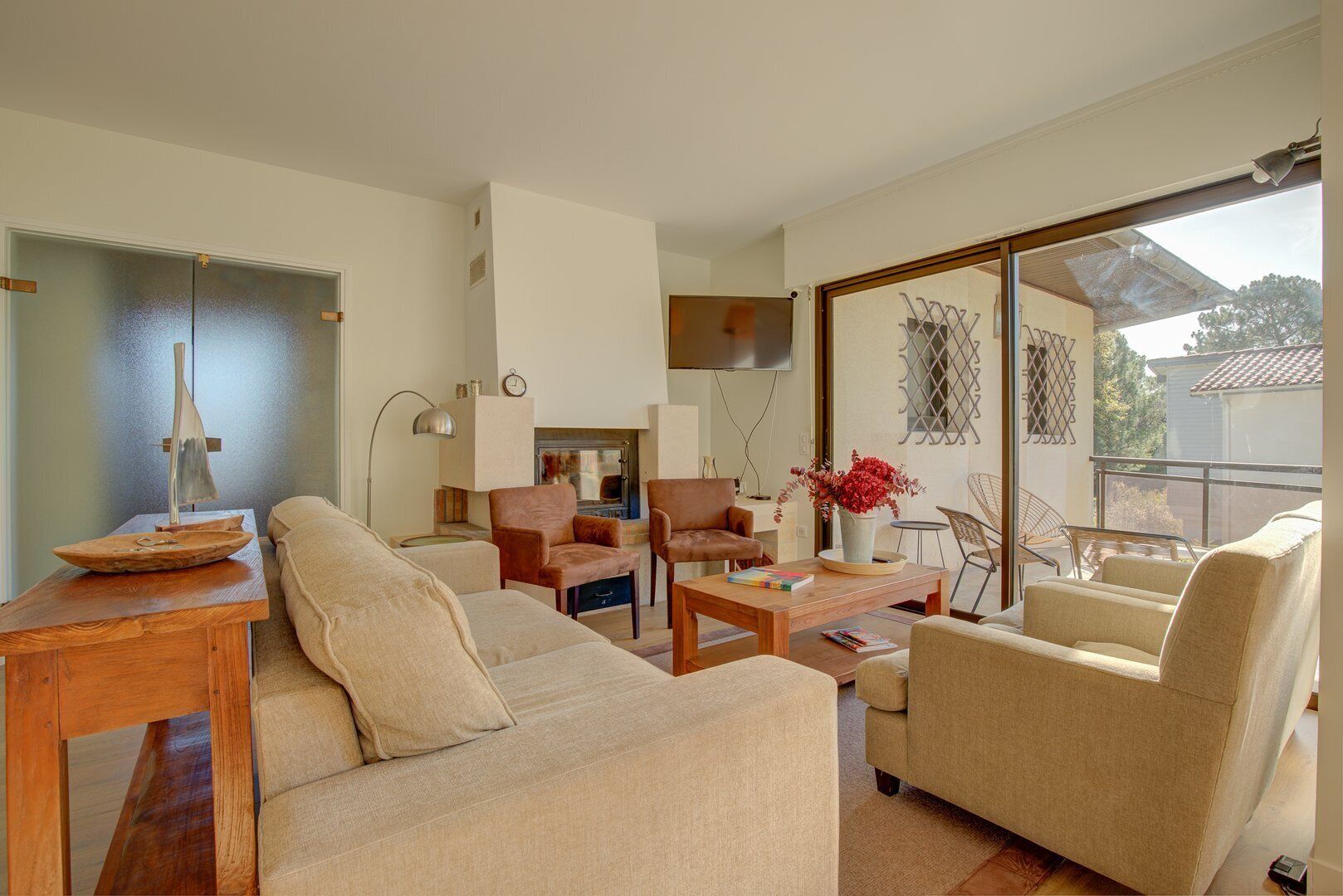 A modern living room with a sofa, armchairs, a coffee table, and a TV.
