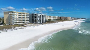 Hotel à beira-mar com várias varandas e uma praia de areia.