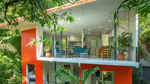 Ett modernt hus med en balkong, en inredd sittplats och krukväxter.