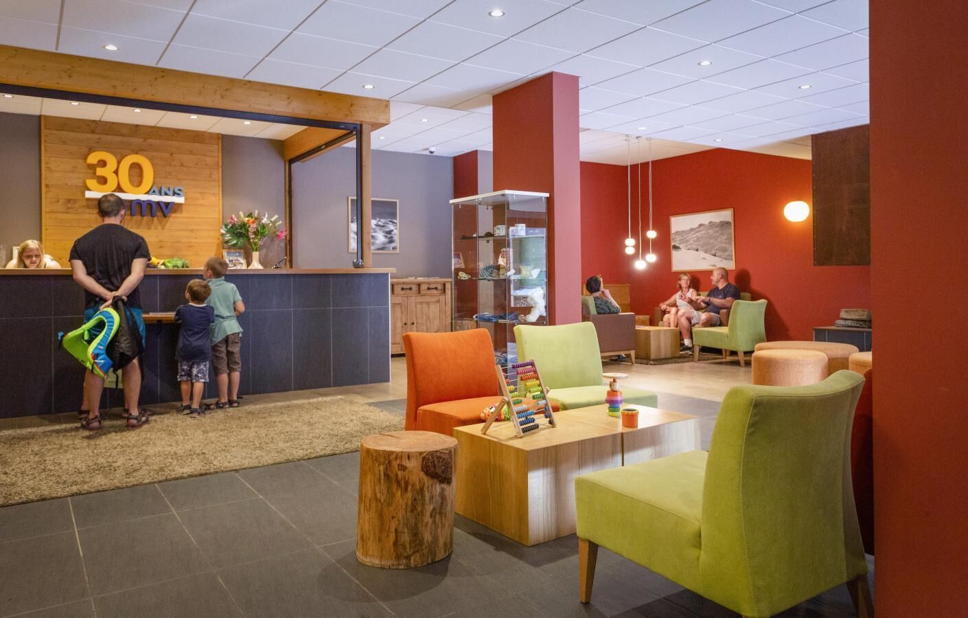 A reception area with a counter, seating area, and a children's play area.
