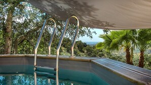 An outdoor swimming pool with metal ladders, surrounded by lush greenery and palm trees. - Rustic 3-bedroom Country Retreat With Pool, Free Wi-fi, and Breathtaking Views (Tavira)