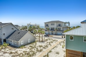 Uma área residencial à beira-mar, com casas, uma praia de areia e vista clara para o oceano.