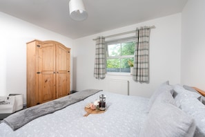 Relax in this inviting bedroom with a large bed, a wardrobe, and a convenient coffee station.