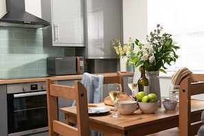 Enjoy a meal at the dining table, complete with a microwave and stainless steel range hood.