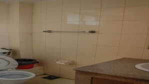 Une salle de bain avec deux toilettes, un lavabo et un sèche-mains.