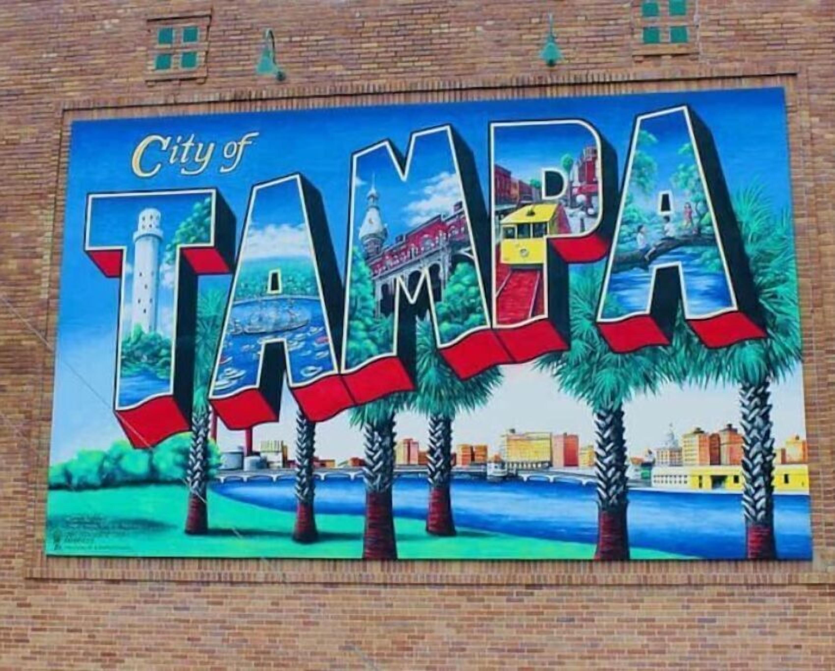 Un mural con las palabras "City of Tampa" y una representación del horizonte de la ciudad, incluyendo un faro y palmeras.