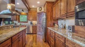 A kitchen with wooden cabinets, granite countertops, stainless steel appliances, and a window with a view. - BIG downtown home w/ views and great amenities! (Breckenridge)