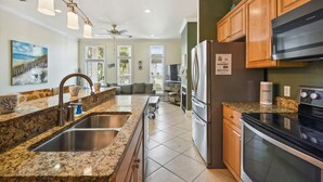 Eine moderne Küche mit Granit Arbeitsplatten, Edelstahlgeräten und Holzschränken.