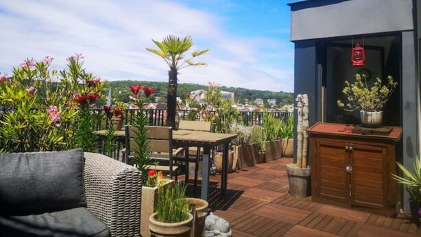 A rooftop patio with outdoor furniture, potted plants, and a view of the cityscape. - ★ Beautiful Rooftop between Paris and Versailles ★ (Chaville)