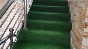 Una escalera con alfombra verde y barandillas de metal.