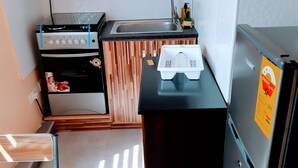 Cocina compacta equipada con microondas, estufa, fregadero y refrigerador.