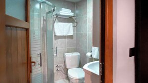 A bathroom with a glass shower enclosure, a toilet, and a sink. - NEPTÜN INN (Kirklareli)