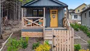 A cabin with a wooden deck, a yellow door, and a number 417 sign. - New* Seabrook's Hammerbarn: Dog Friendly! (Pacific Beach)