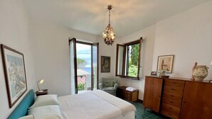 A bedroom with a bed, a desk, a chair, a dresser, and a view of the outdoors. - Villa with sea view Sestri Levante (Sestri Levante)