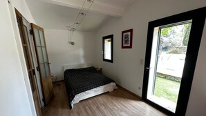 Een slaapkamer met een bed, een raam en een deur.