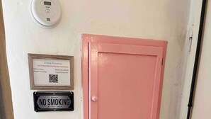 Ein rosa Schrank mit einem 'NICHTRAUCHEN'-Schild und einem WLAN-Symbol an der Wand.