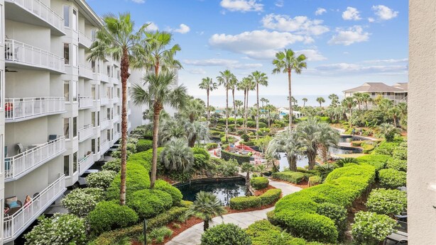 Um hotel com vários andares, piscinas ao ar livre e palmeiras.