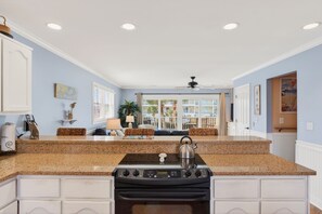 A kitchen with granite countertops, a stove, and a ceiling fan. - Community Pool, 3bdrm (Cape San Blas)