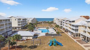 A resort with multiple-story buildings, a swimming pool, and a playground. - Community Pool, 3bdrm (Cape San Blas)