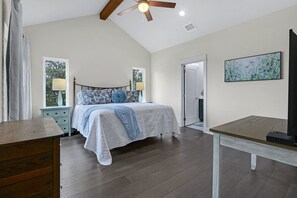A bedroom with a bed, bedside tables, a ceiling fan, and a painting on the wall. - View La La! I Hot tub, gameroom, Canyon Lake (Canyon Lake)