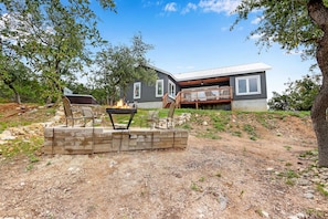 A modern house with a deck, a fire pit, and outdoor seating. - View La La! I Hot tub, gameroom, Canyon Lake (Canyon Lake)