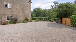 A stone building with a gravel driveway and a wooden gate. - Luxurious Bolthole (Matlock)