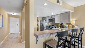 A modern kitchen with granite countertops, stainless steel appliances, and bar stools. - Closely located to Seascape Golf Course & Seascape Village (Aptos)