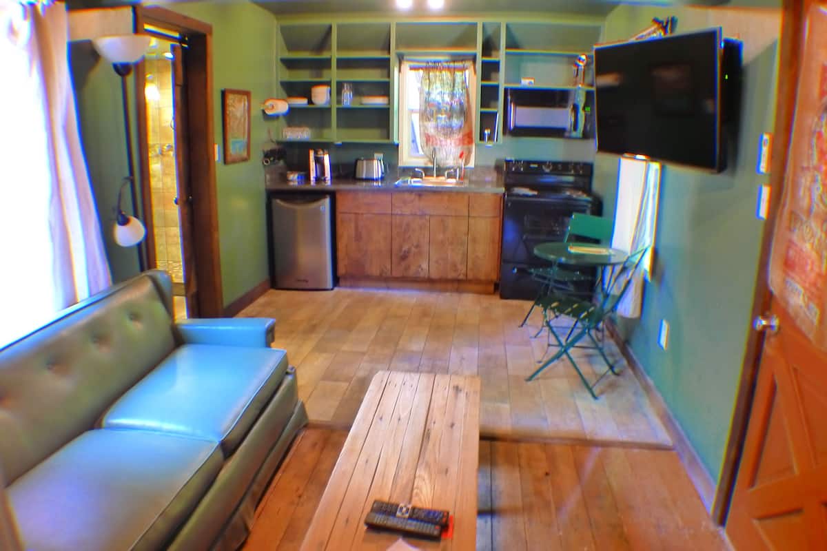 A compact kitchen with a wooden countertop, a built-in oven, and a microwave.