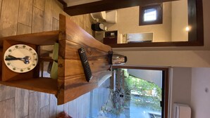 A kitchen with a wooden table, a coffee maker, and a clock. - Vila Tamu (Imbituba)