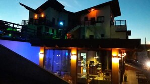 A two-story building with a balcony and a glass enclosure. - Vila Tamu (Imbituba)
