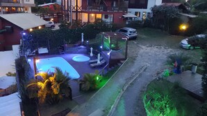 A residential area with a swimming pool, outdoor seating, and a covered deck area. - Vila Tamu (Imbituba)