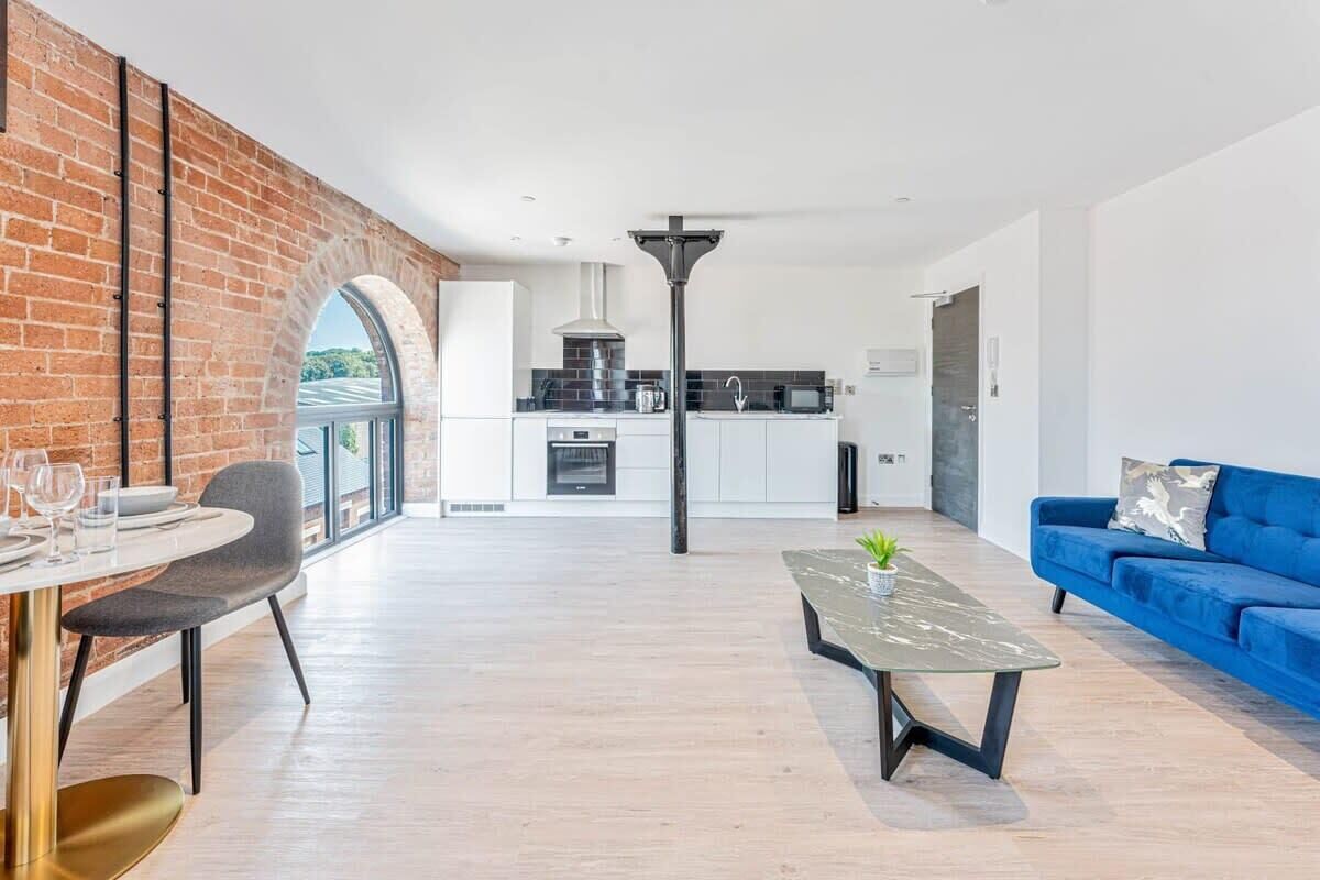 A modern apartment with a dining area, kitchen, and living space.