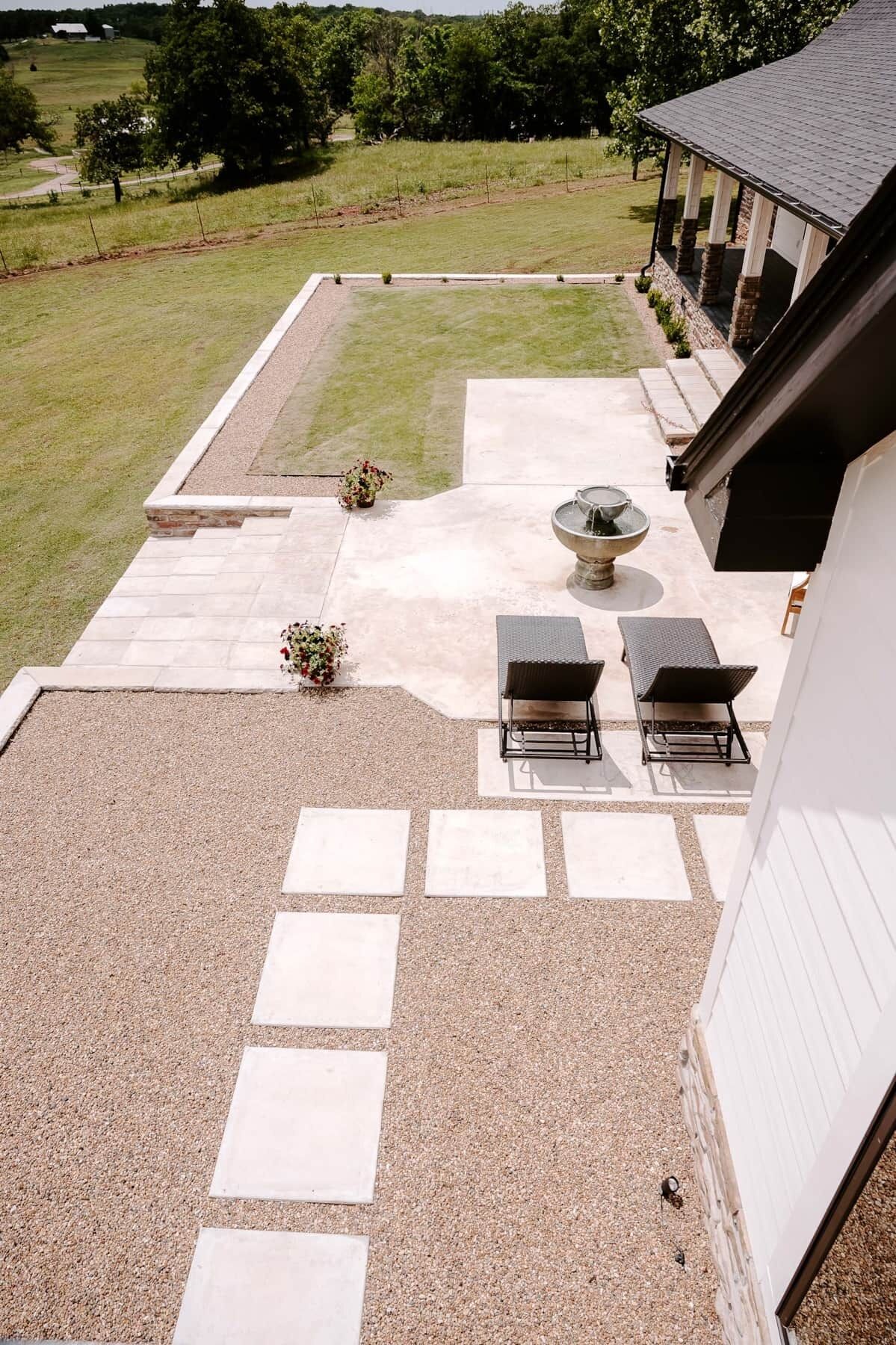 Une terrasse avec deux chaises longues, une petite table et un vase décoratif.