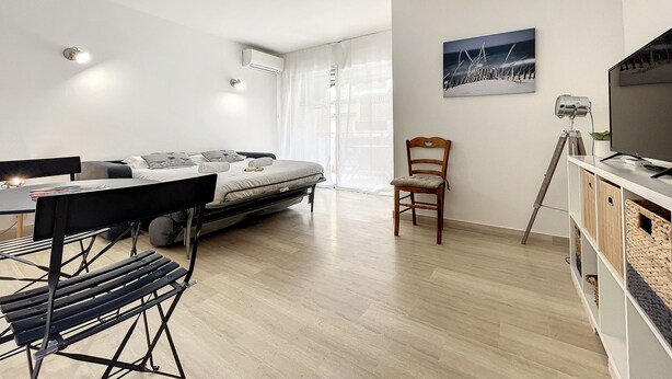 Une chambre moderne et bien éclairée, équipée d’un lit, d’un bureau, d’une chaise et d’un téléviseur.