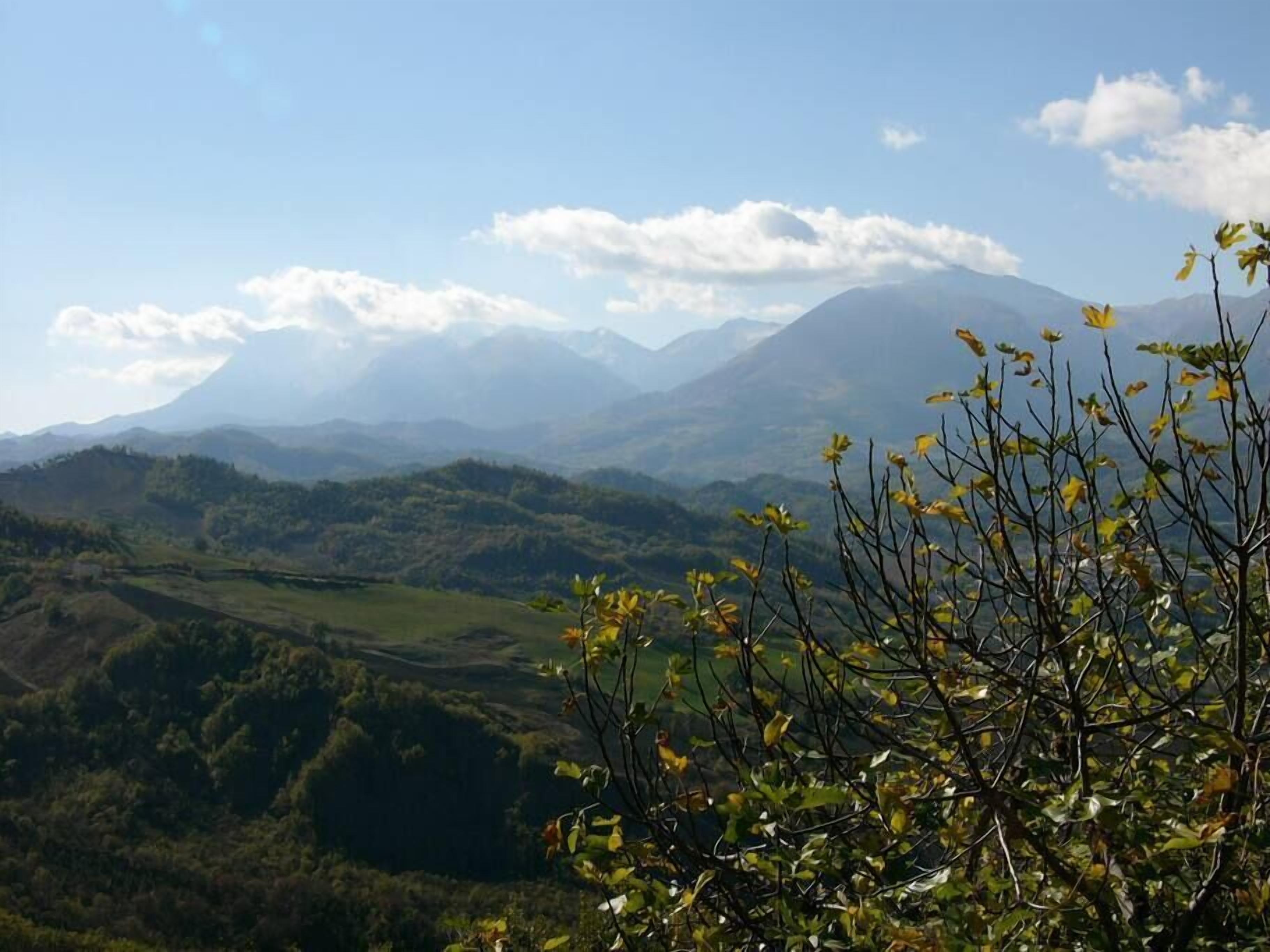 A mountainous landscape with a clear sky and distant mountains.
