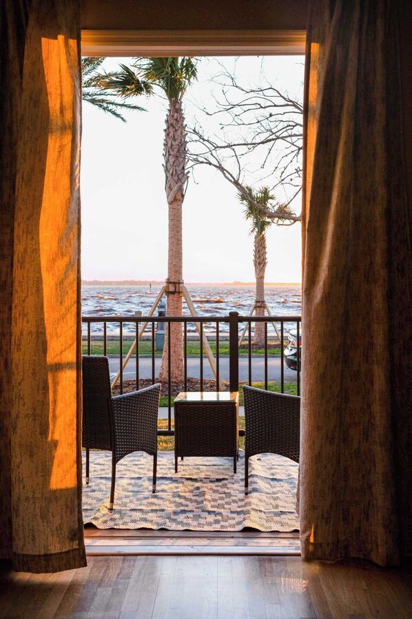A balcony with wicker furniture and a view of the ocean.