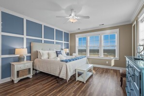A bedroom with a bed, nightstands, a bench, a dresser, and a ceiling fan. - The Pressian: Oceanfront, Pool & Hot Tub (Garden City Beach)