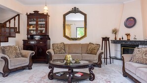 Un salon comprenant un ensemble de canapés, une table basse, un meuble et une cheminée.
