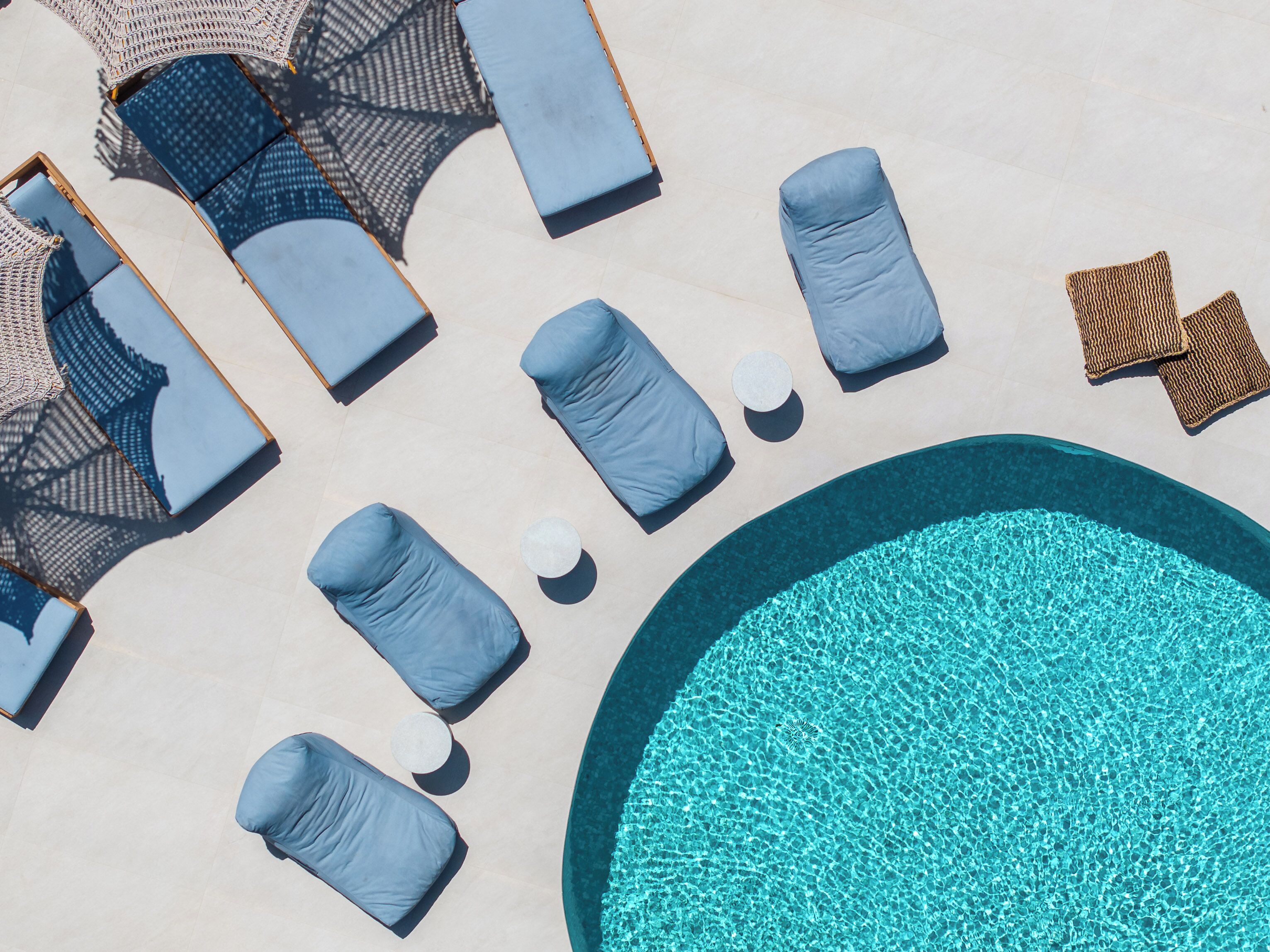 A poolside area with lounge chairs and a round pool.