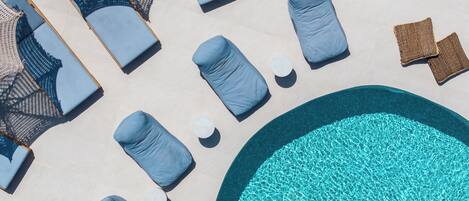 A poolside area with lounge chairs and a round pool.