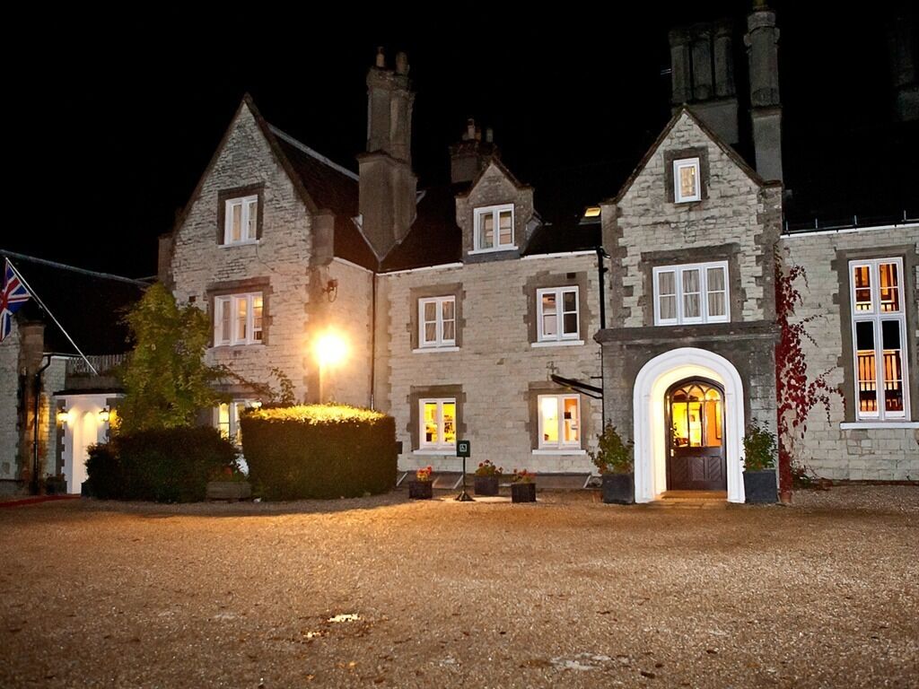A stone building with multiple windows and a well-lit entrance.