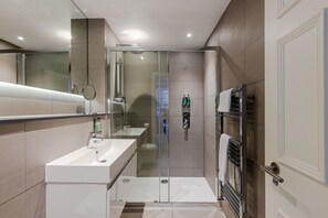 Enjoy a contemporary bathroom with a glass-enclosed shower, standalone sink, and towel rack.