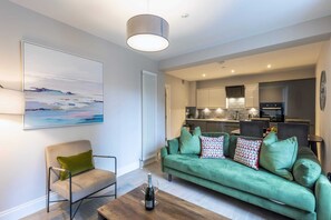 Relax in this stylish living area with a sofa, armchair, and coffee table, perfect for unwinding with a glass of wine.