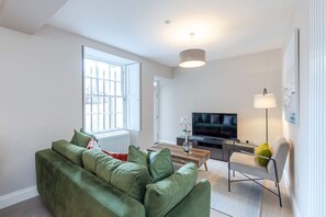 Relax in this stylish living room with a sofa, coffee table, and TV.