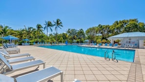 A swimming pool with lounge chairs and umbrellas, surrounded by palm trees. - Marina to Ocean View Key Largo Ocean Pointe 5308 (Tavernier)
