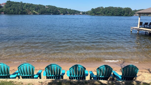 A lakeside view with chairs and a dock. - Lake house with access to the best beach for swimming & fishing on Lake Hamilton (Hot Springs)